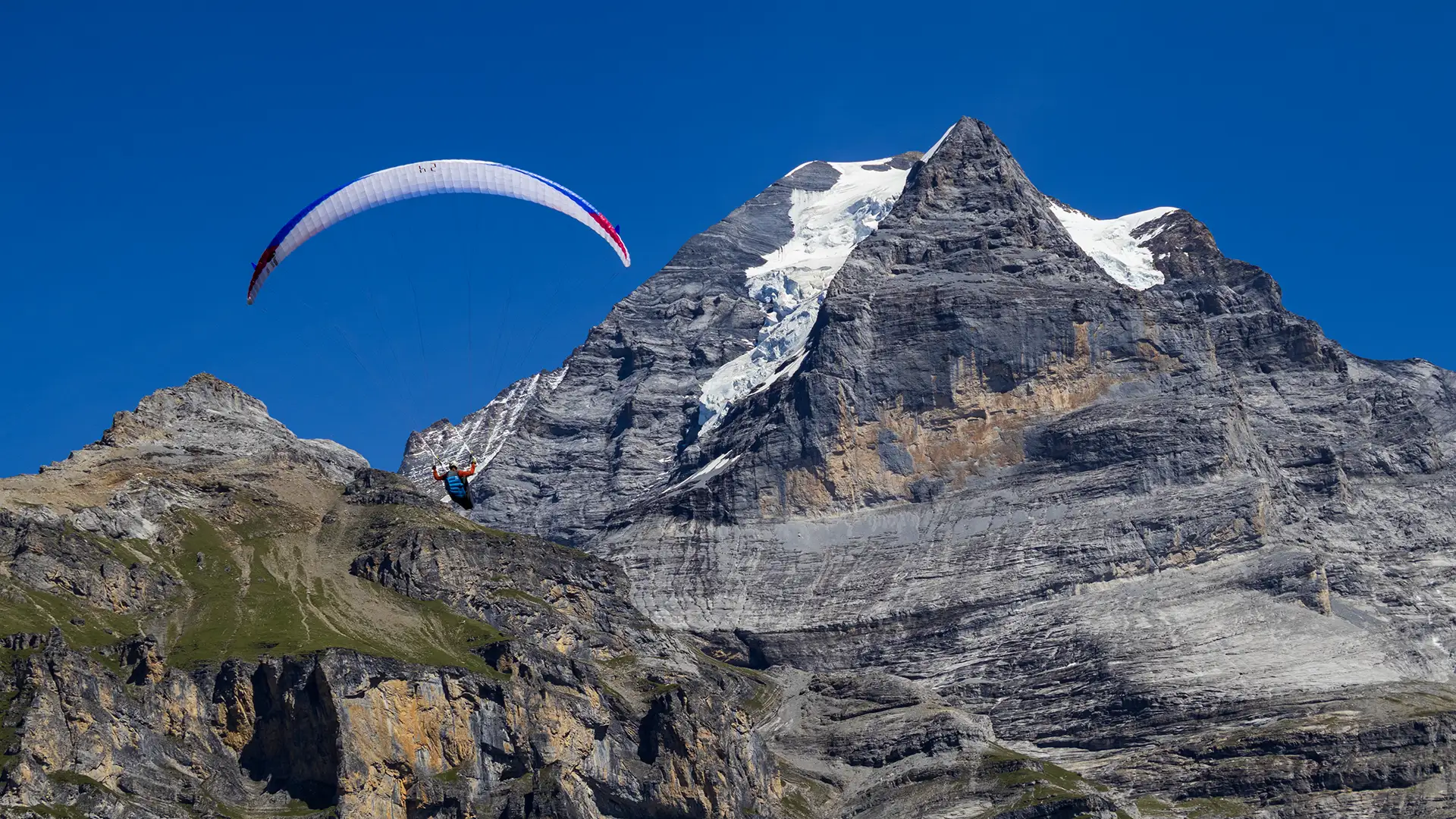 Paraglider flying in the mountains after takeoff