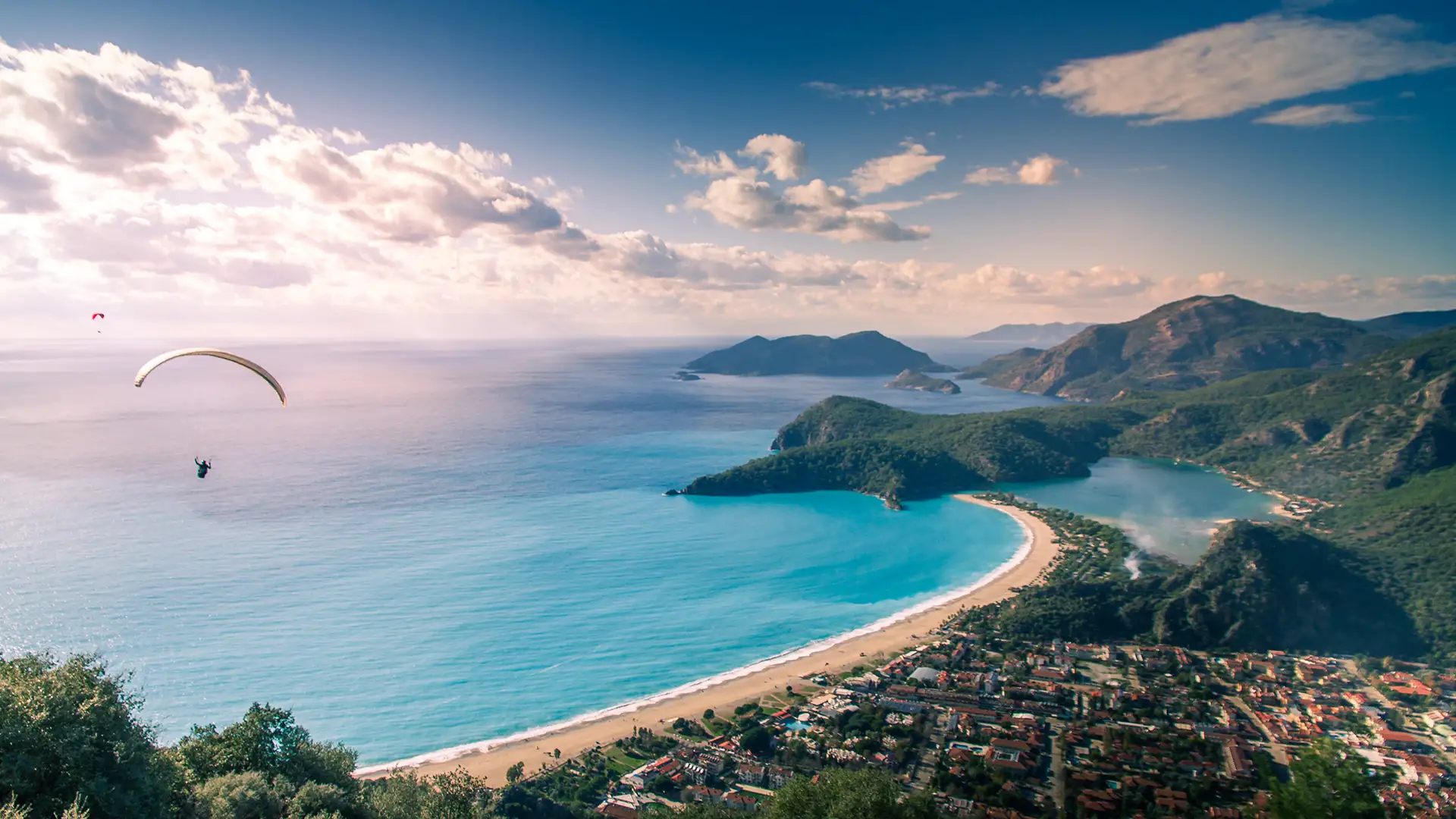 Paraglider flying along the coast in beautiful light